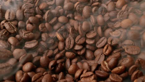 cerca de las semillas de café. los granos de café perfumados son tostados el humo viene de los granos de café.