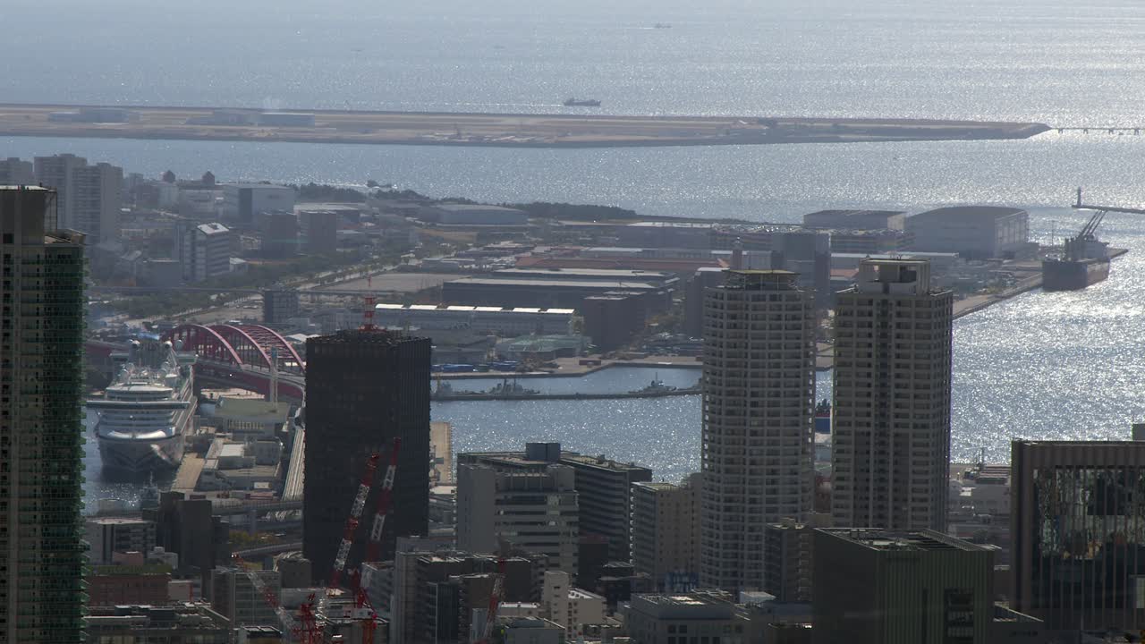 L'acqua dell'oceano luccica al sole: skyline del lungomare della città di Kobe, isole