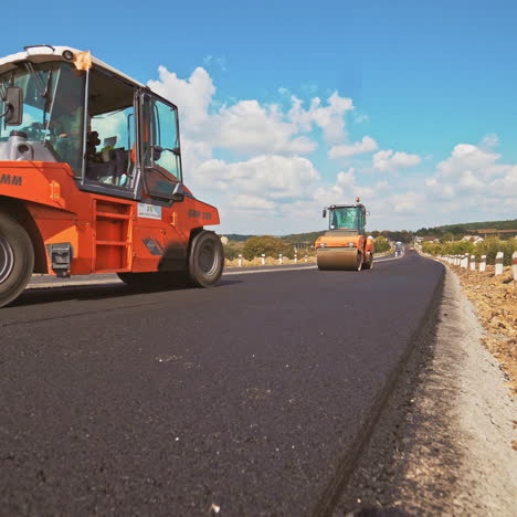workers carry out construction and repair works of roads with the help of professional equipment near the city in the summer. close-up