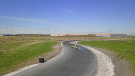 green racing car drifting on a track with smoking tires and skid marks on an asphalt