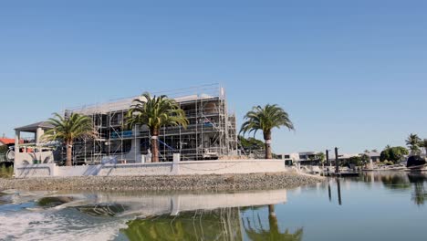 house under construction near a calm canal