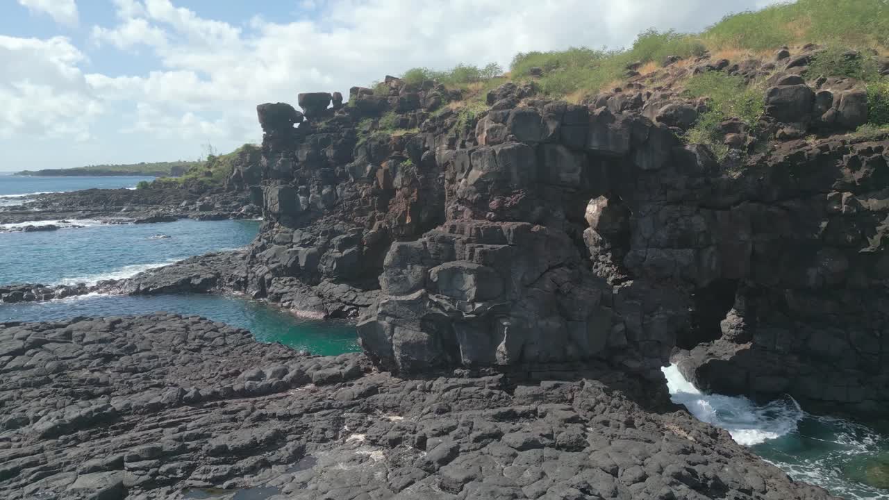 Mauritius - Albion - left orbit view on the stone arch with a boat in the background