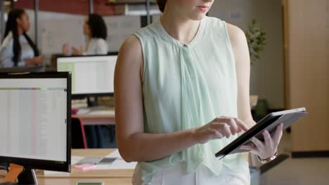 Portrait-of-happy-caucasian-casual-businesswoman-using-tablet-smiling-at-office,-slow-motion