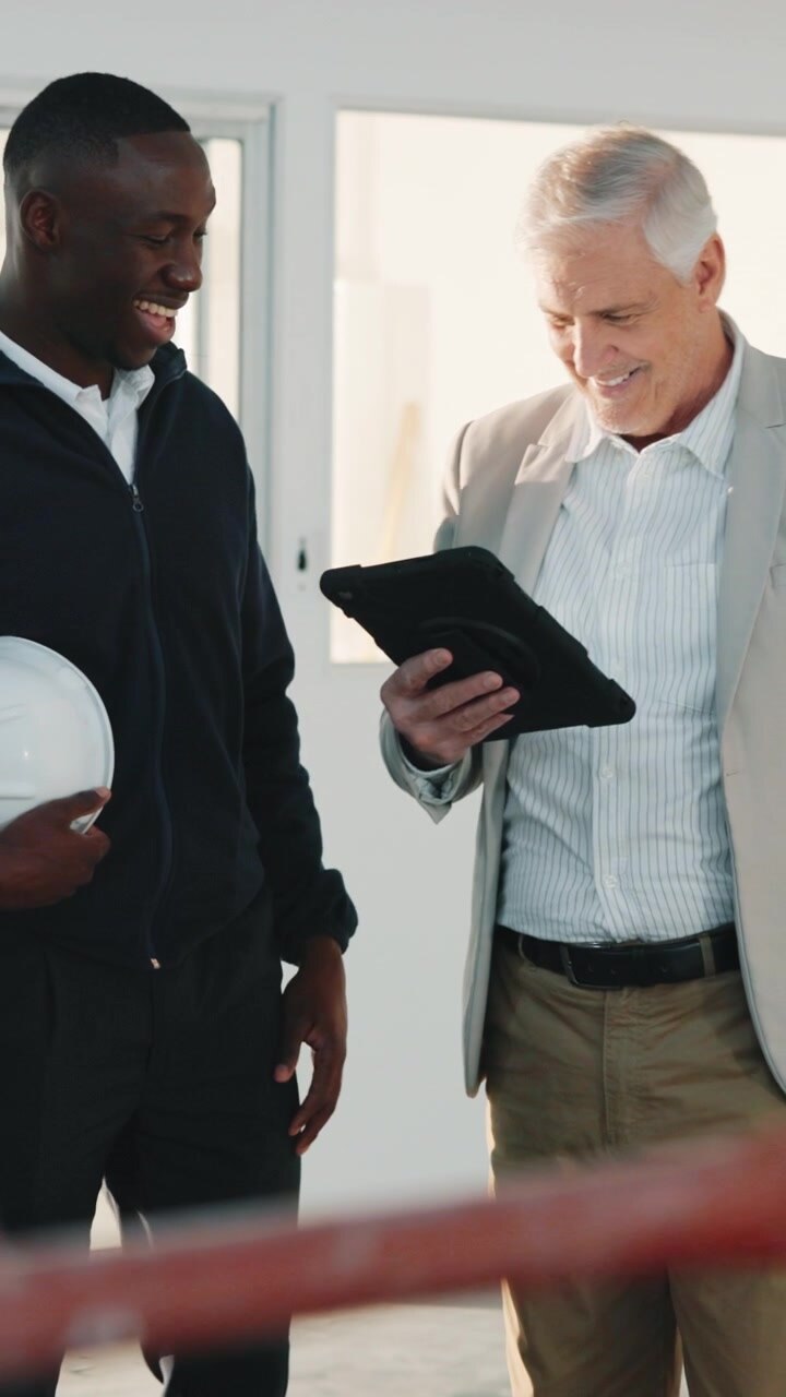 Architetto e appaltatore discutono i piani di costruzione su un tablet