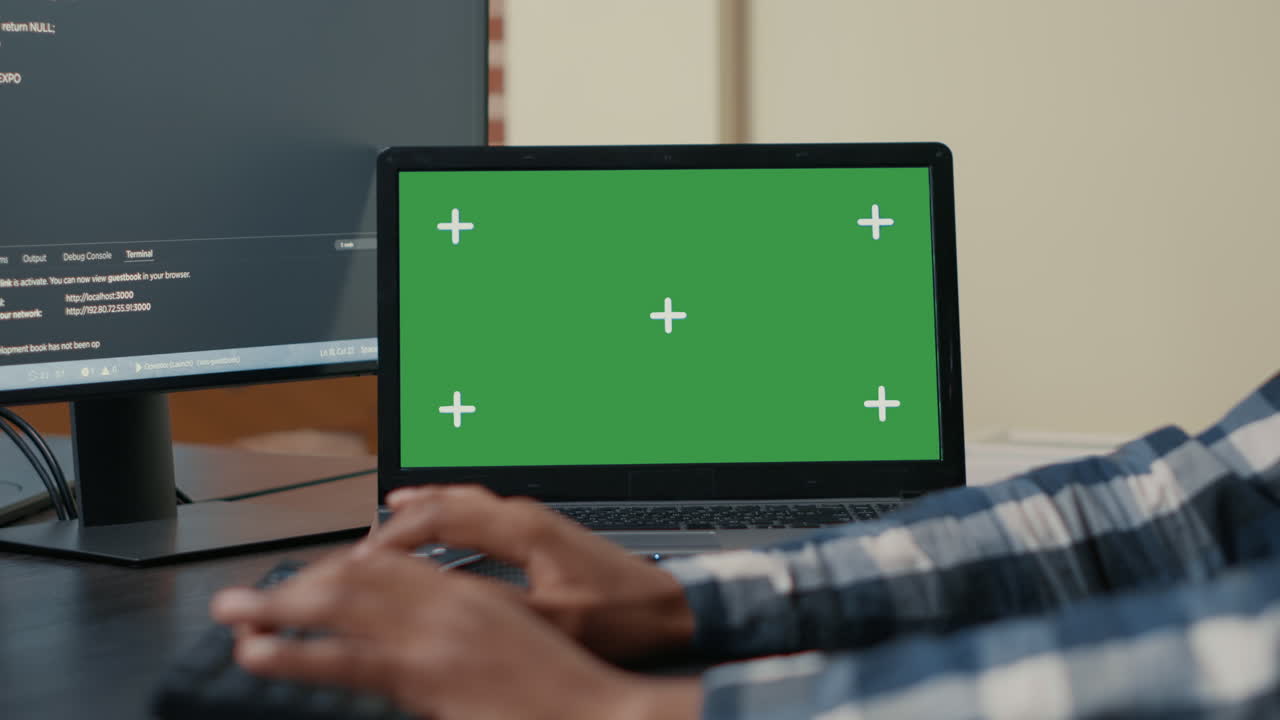 Closeup of laptop with green screen chroma key mockup and african american hands writing code
