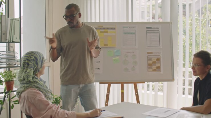 Black Male Teacher Talking by Whiteboard during Lesson