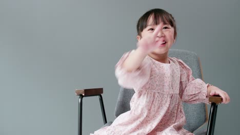 cheerful and happy child looking at camera and swing arms and pointing to something