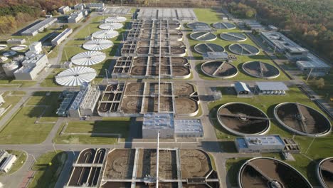 aerial establishing shot of a huge sewage treatment plant on evening flying forward