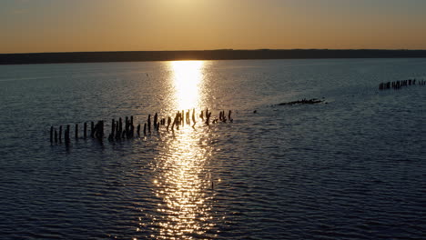 Luftaufnahme-Der-Salzgewinnung-Bei-Orangefarbenem-Sonnenuntergang.-Seewasseroberfläche