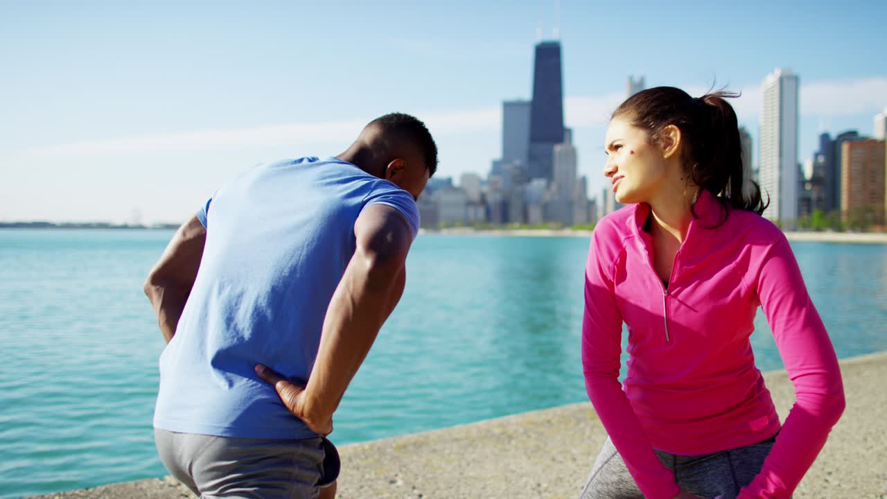 varones y mujeres multiétnicos estirándose después del entrenamiento