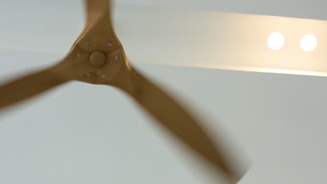 ceiling fan blades spinning under bright lights