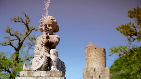 waterspout spring statue slow motion water dripping with tower in the background