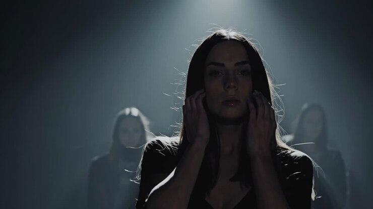 Moody video scene with a low-angle shot, highlighting a woman in shadowy lighting