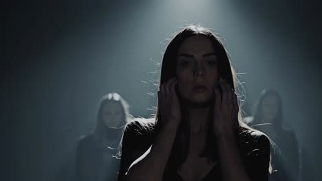 moody video scene with a low-angle shot, highlighting a woman in shadowy lighting