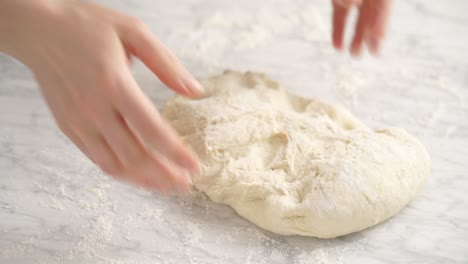 anonymous woman kneading dough for pizza