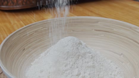 chef puts down the pizza dough into a deep plate