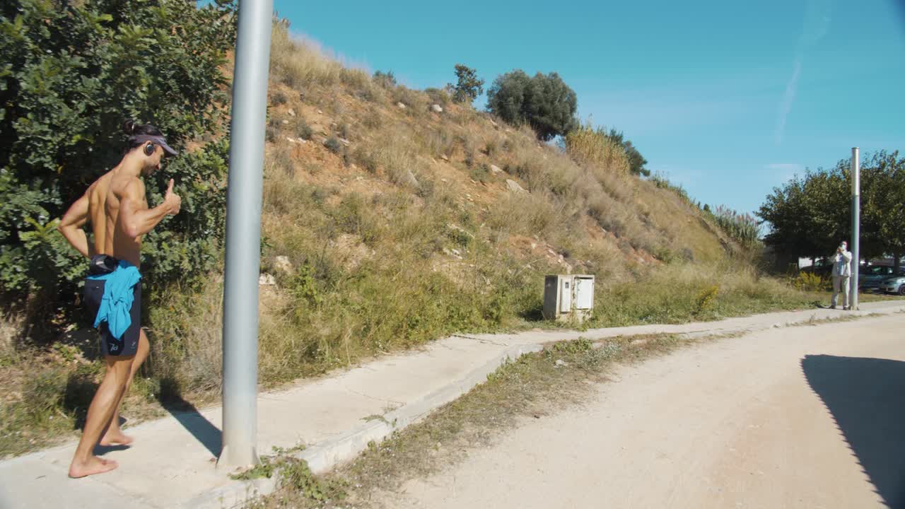 A runner runs barefoot as he reaches the finish line after running 60 kilometers barefoot on a sunny day