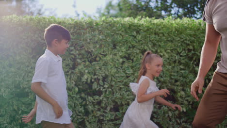 parents with children playing blind man buff. man eyes tied with blindfold