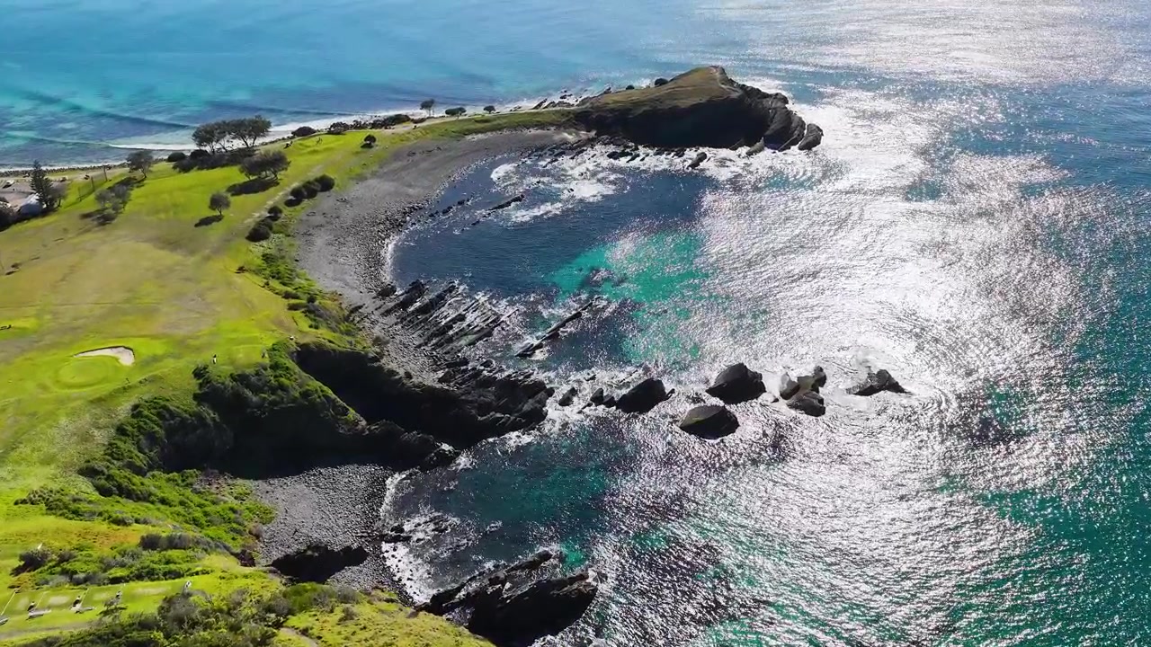 Ripresa aerea con drone di promontori rocciosi e acqua cristallina turchese a Crescent Head, Australia