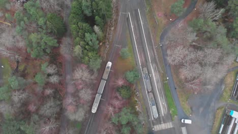 bird's eye view following a tram as it travels along a railway in sweden