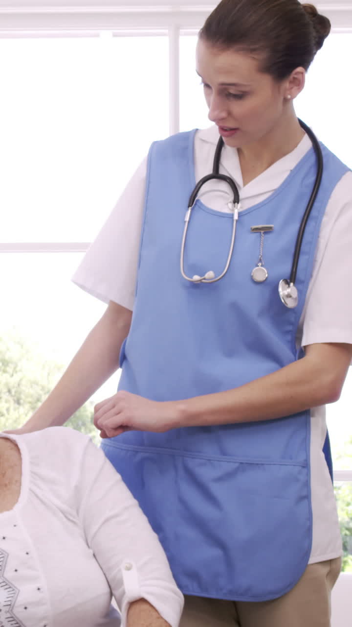 Cheerful nurse talking with senior woman