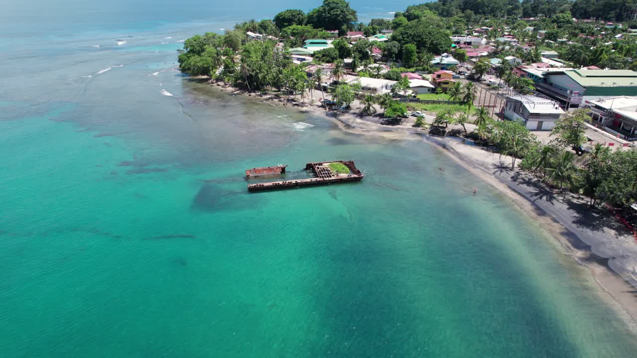 Aerial view of Puerto Viejo beach with a smooth orbit revealing clear waters and coastline under daylight.