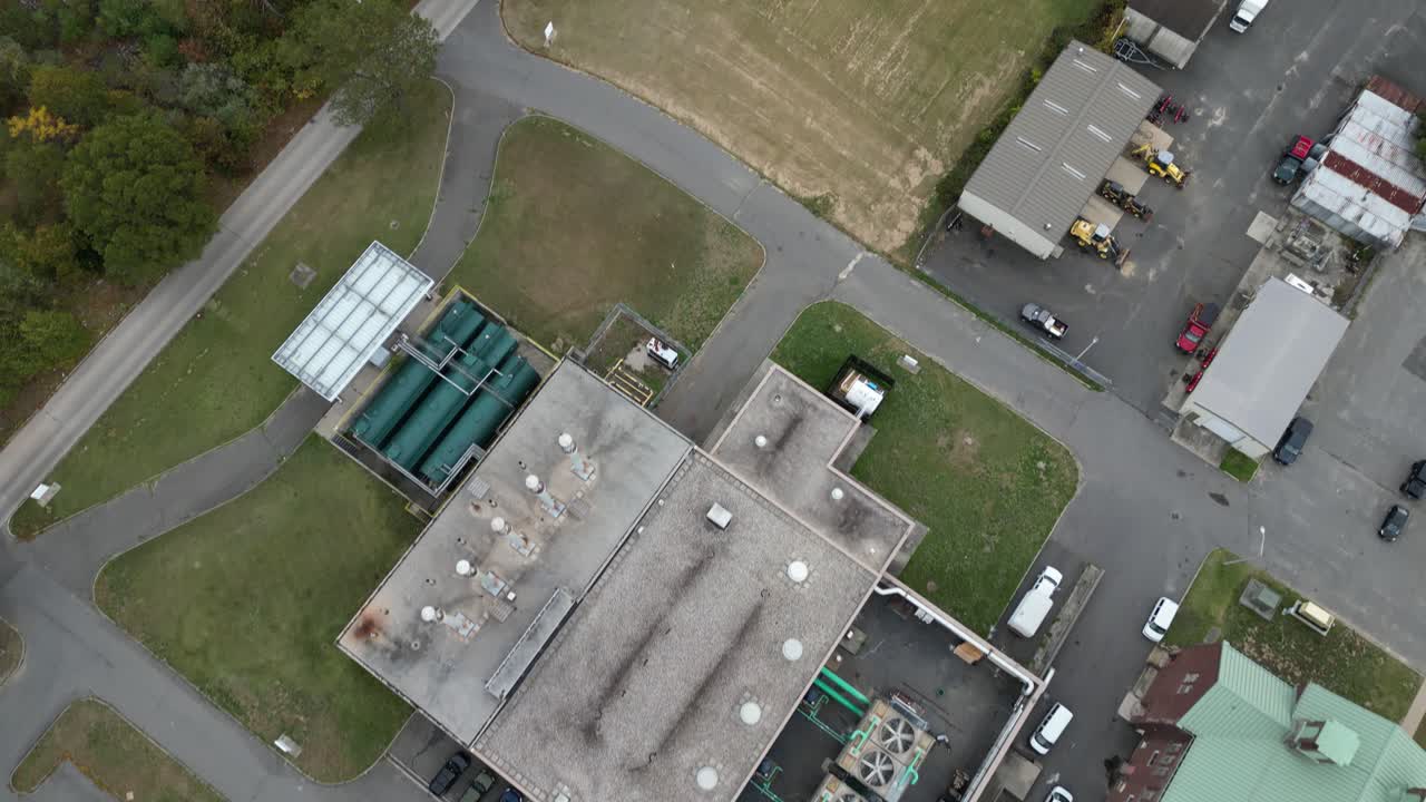 Aerial drone view of a large medical campus in Brentwood, Suffolk County, Long Island, NY, showcasing multi-wing architecture, structured parking, open grounds, and surrounding landscape in clear day