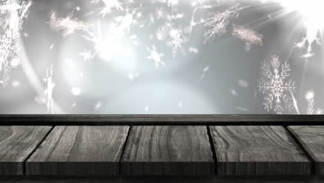 animation of snowflakes falling with wooden surface over grey background