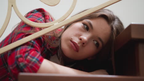 bored woman performs sadness on steps closeup. lady with symptoms of seasonal depressions lies on staircase. broken woman disinterested in living