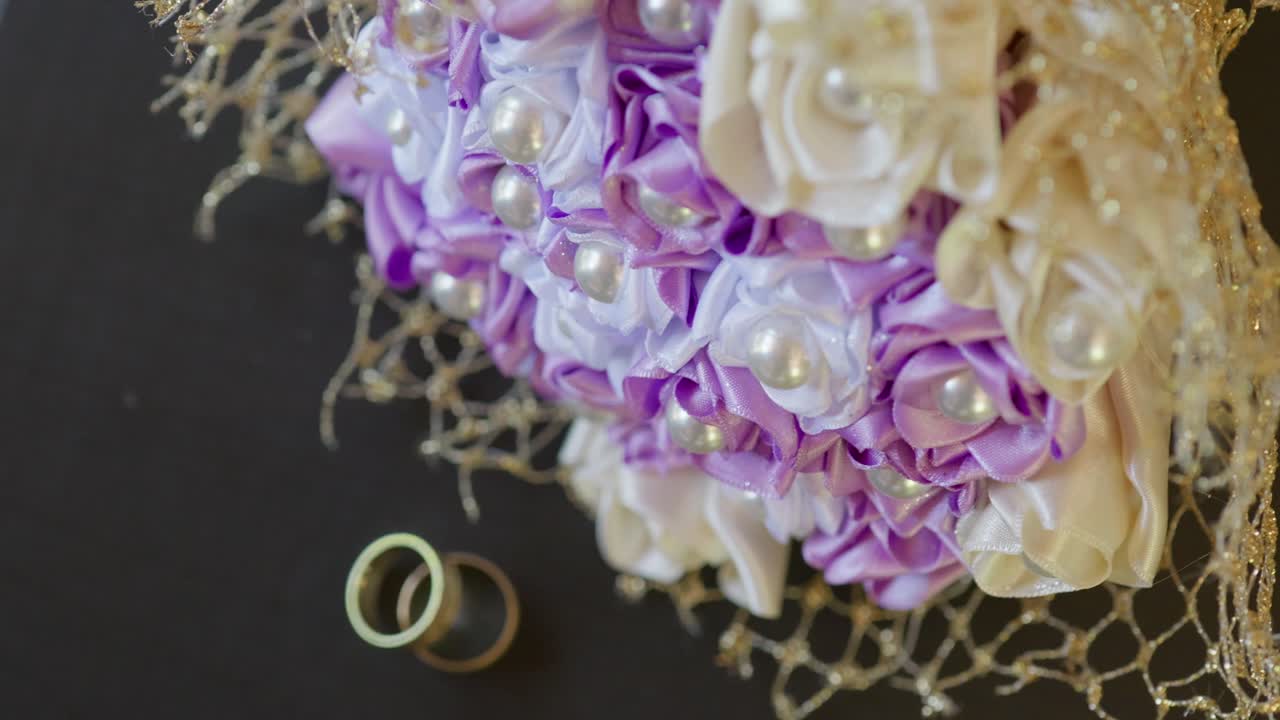 Wedding Rings on Table with Bride's Bouquet
