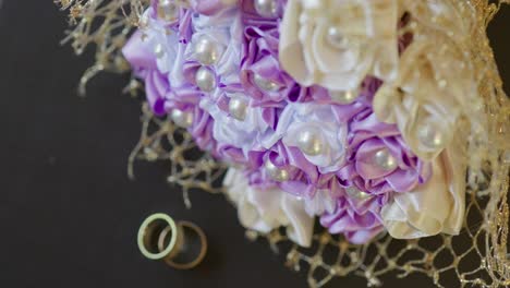 wedding rings on table with bride's bouquet