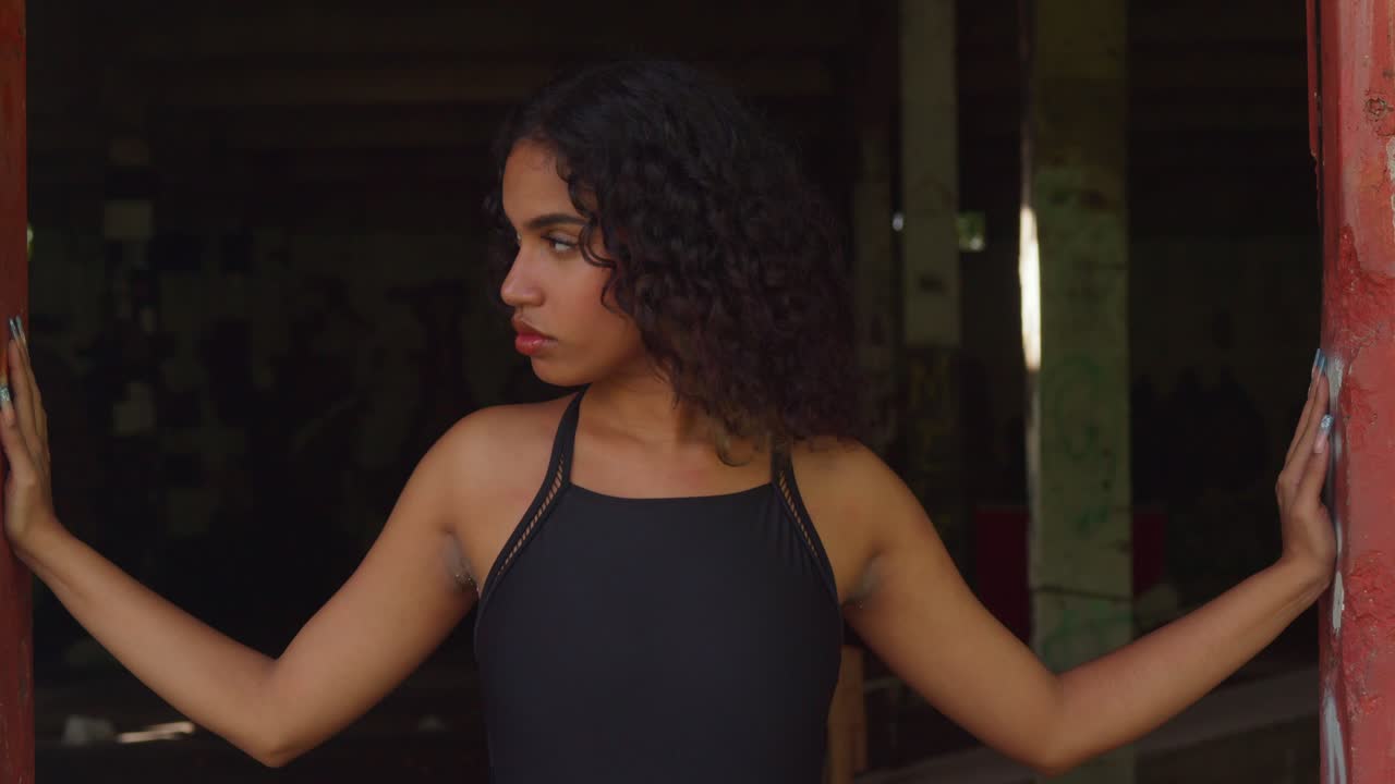 en un edificio cubierto con paredes llenas de graffiti, una joven en bikini se está divirtiendo