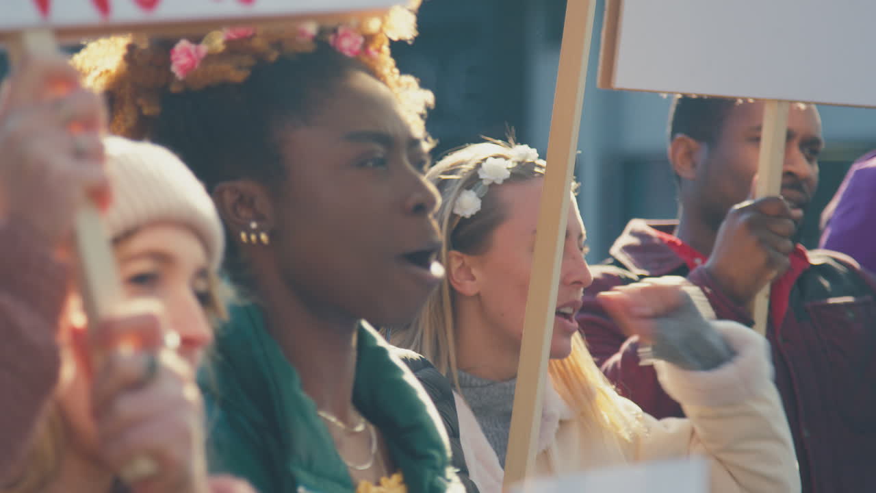 도시 에서 시위 행진 을 하고 있는 플래카드 를 들고 있는 시위자 들 의 사진