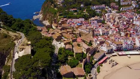 flying upwards, above a historic medieval city on the coastline of the mediterranean sea