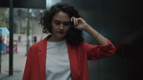 Young Woman in Red Jacket, Pensive in Urban Alley