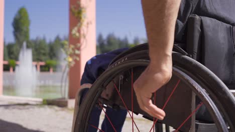 Close-up-hand-of-disabled-person-turning-wheelchair-wheel.