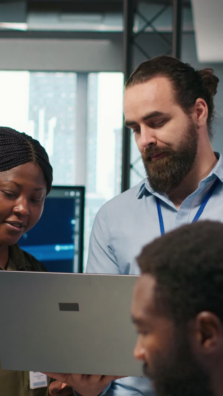 Vertical video Teamworking programmers in office reviewing AI system metrics