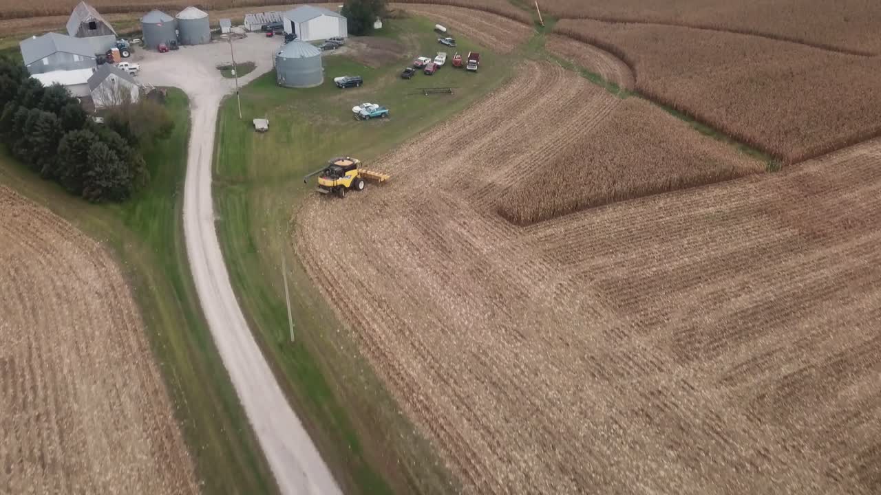 sobrevuelo de drones de un campo de maíz cosechado hacia el corral con tolvas de grano, graneros y otros equipos agrícolas en la zona rural de iowa