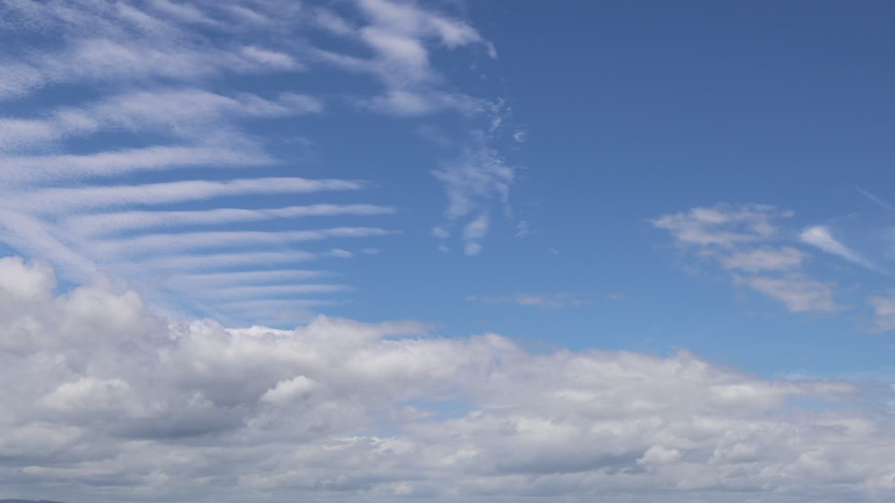 Cloud formations changing rapidly in a blue sky
