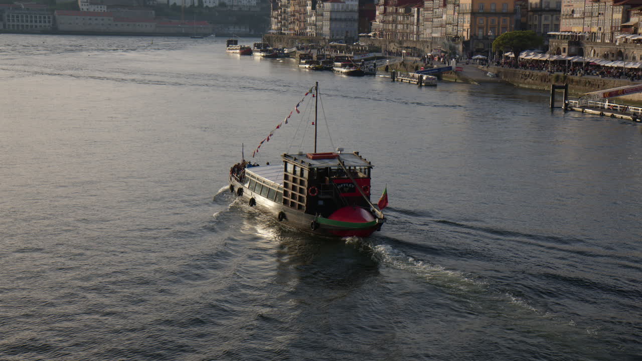 Traditional Portuguese boat sailing Douro River in Porto. Tilt up