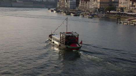 traditional portuguese boat sailing douro river in porto. tilt up