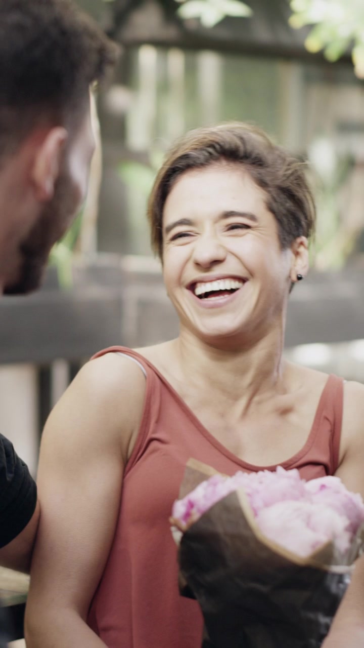 Happy Woman Receiving a Bouquet of Flowers from Her Partner