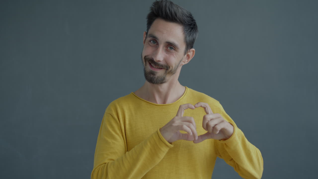 hombre haciendo forma de corazón con las manos