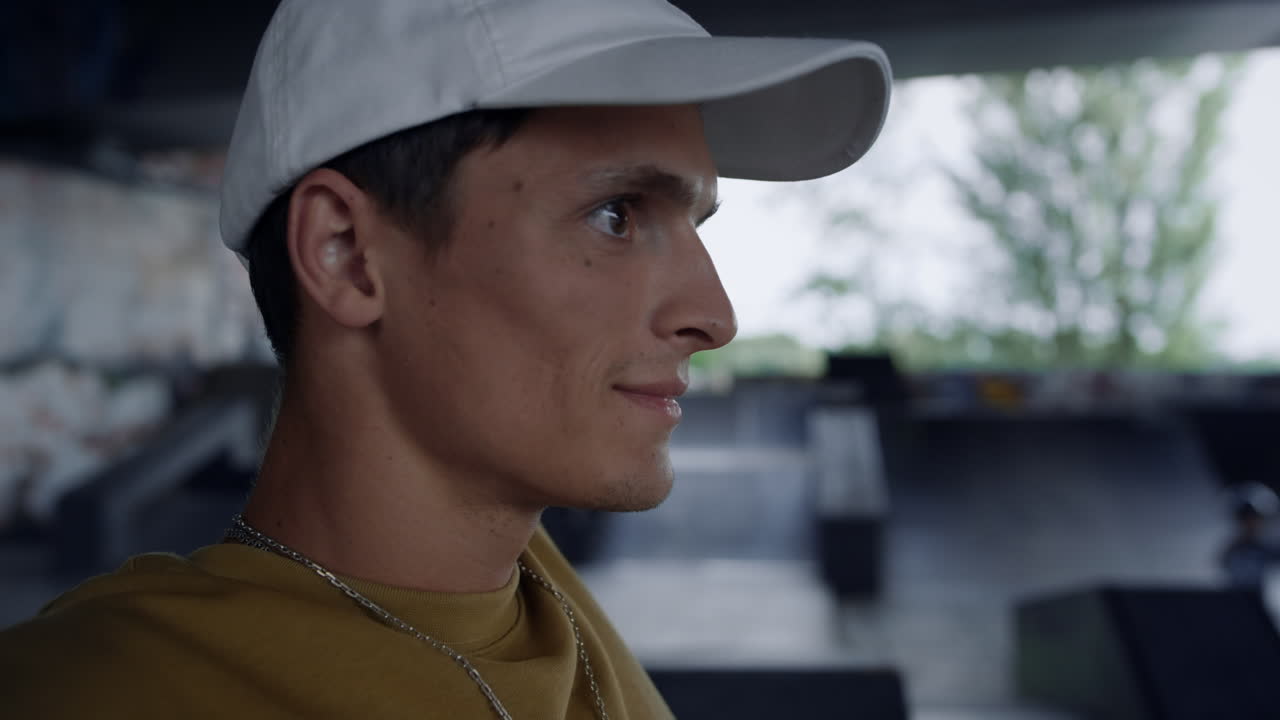 스케이트파크에서 훈련을 하고 있는 미소 짓는 남자.  ⁇ 으로 보는 남자.