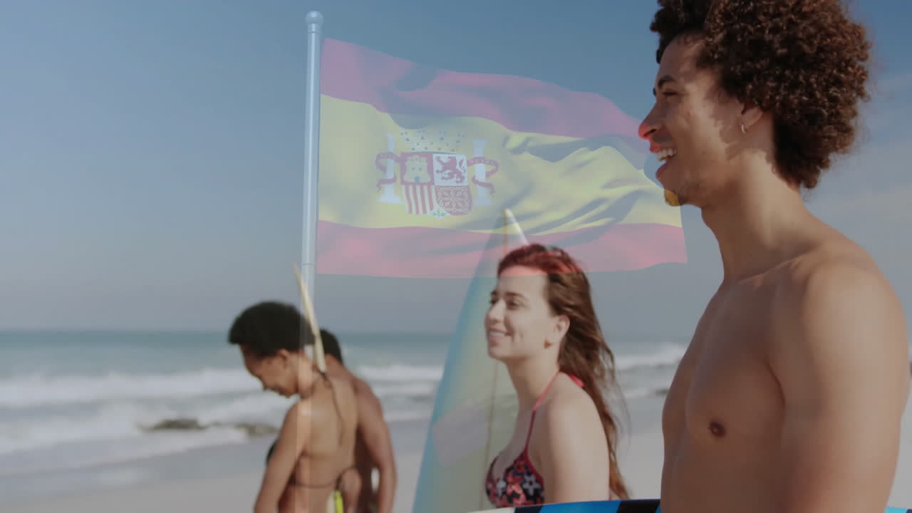 Walking on beach, young people with Spanish flag waving in background