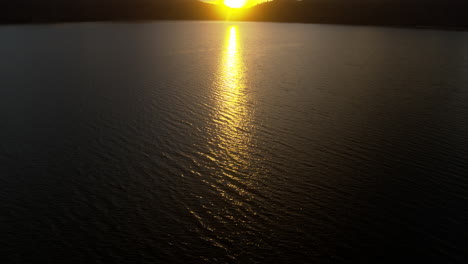 pan sobre un lago iluminado por el amanecer en el rojo de california