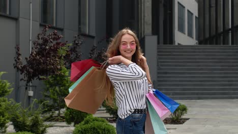 chica caminando con bolsas de compras coloridas, regocijándose de los descuentos en la tienda de moda, disfrutando de las compras