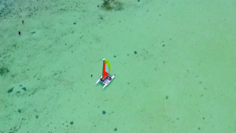 Catamarán-Con-Velas-De-Colores-Navegando-En-Aguas-Turquesas-Del-Mar-Caribe