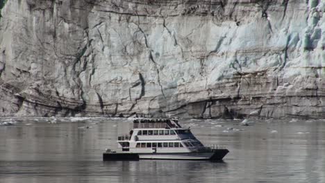 small boat in front of a glacier in alaska