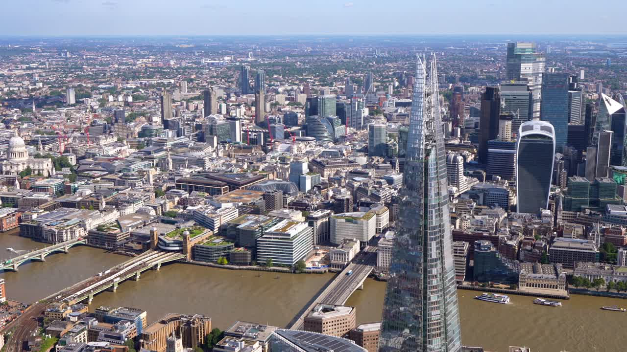 Aerial view of the Shard and London City, pan west to show the River Thames and bridges